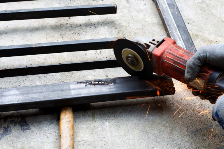 Close up, A man working with angle grinder. Iron gate repair