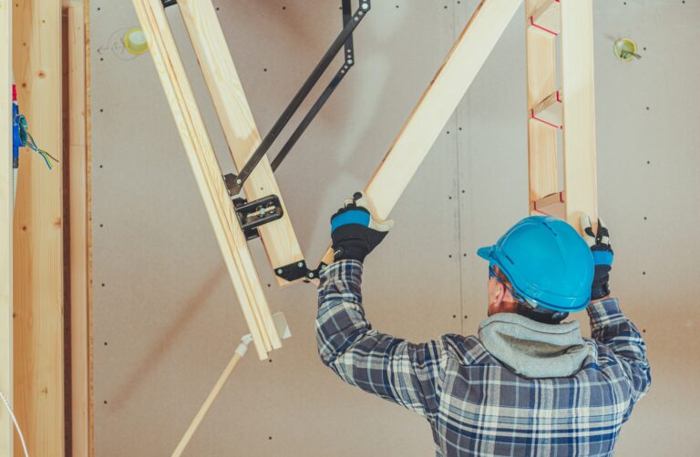 Male Handyman Attaches Parts Of Wooden Access Ladder.